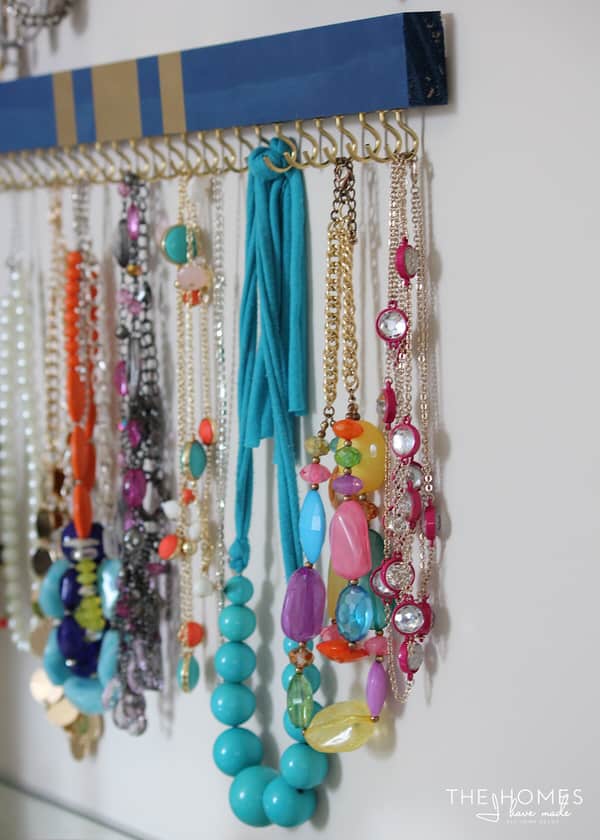 painted wooden boards with cup hooks attached on the bottom side becomes a beautiful jewelry organizer