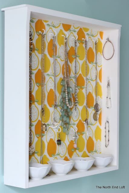a simple drawer is repurposed into a jewelry holder by adding cup hooks on the back and sides.