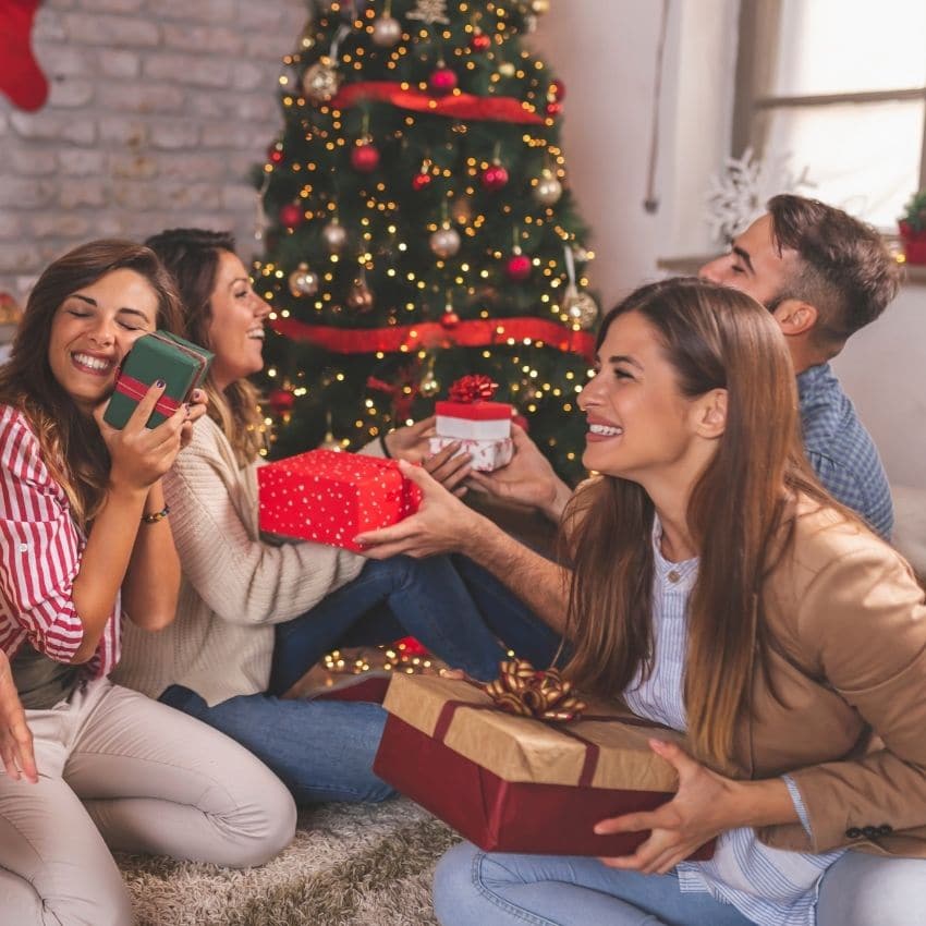 A group of people holding gifts before a gift exchange game starts.