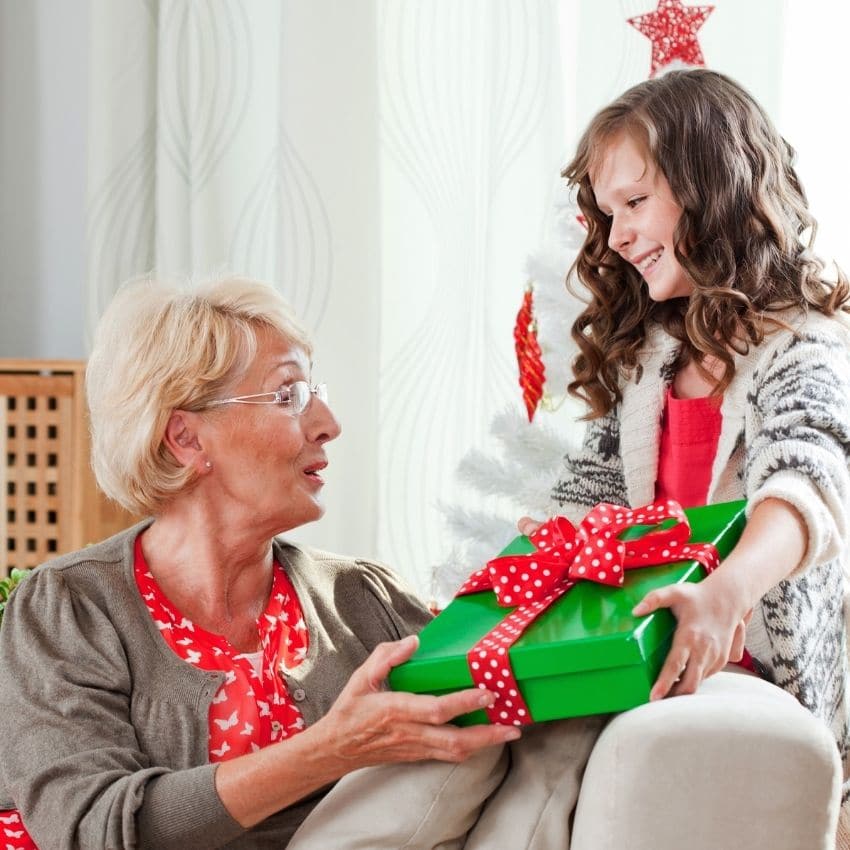 Little girl giving Grandma a gift for a gift exchange game.