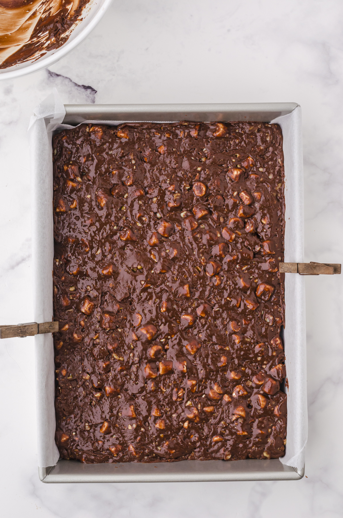 Microwave 5 minute fudge spread into a parchment lined pan ready to be chilled.