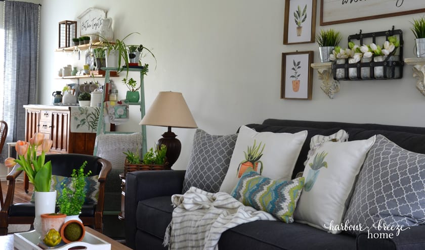 A living room after a Spring refresh has been done with fresh flowers, faux tulips, and printable plant art.