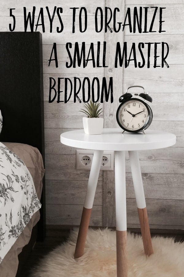 a white table nightstand with a clock on it with the text "5 ways to organize a small master bedroom" written on it