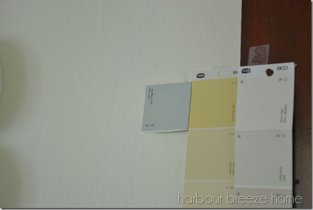 house paint color swatches taped to the wall of a room