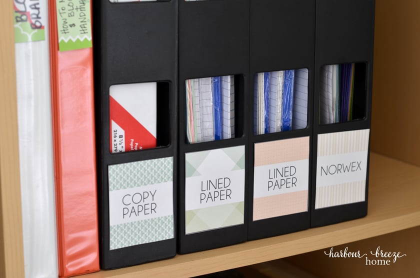 Magazine holders with paper stored in them with labels on each one.