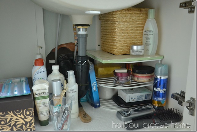 An under the bathroom sink vanity cupboard organized with baskets and shelves so that items can be easily accessed as needed.
