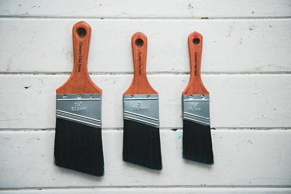 3 paintbrushes hanging on a wall