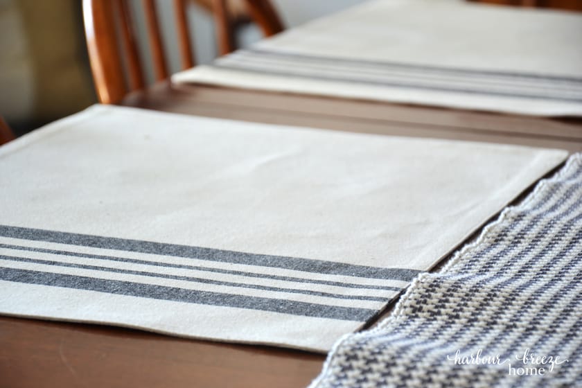 close up picture of a gray striped place mat on a wooden table