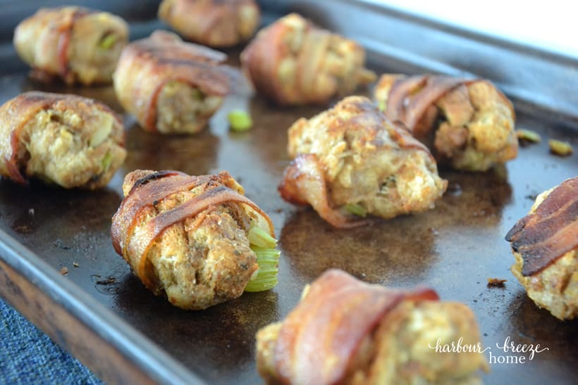 Bacon wrapped stuffing balls on a baking sheet