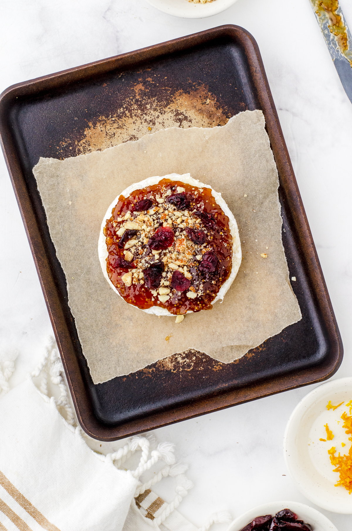 round of brie with fig jam, nuts and cranberries