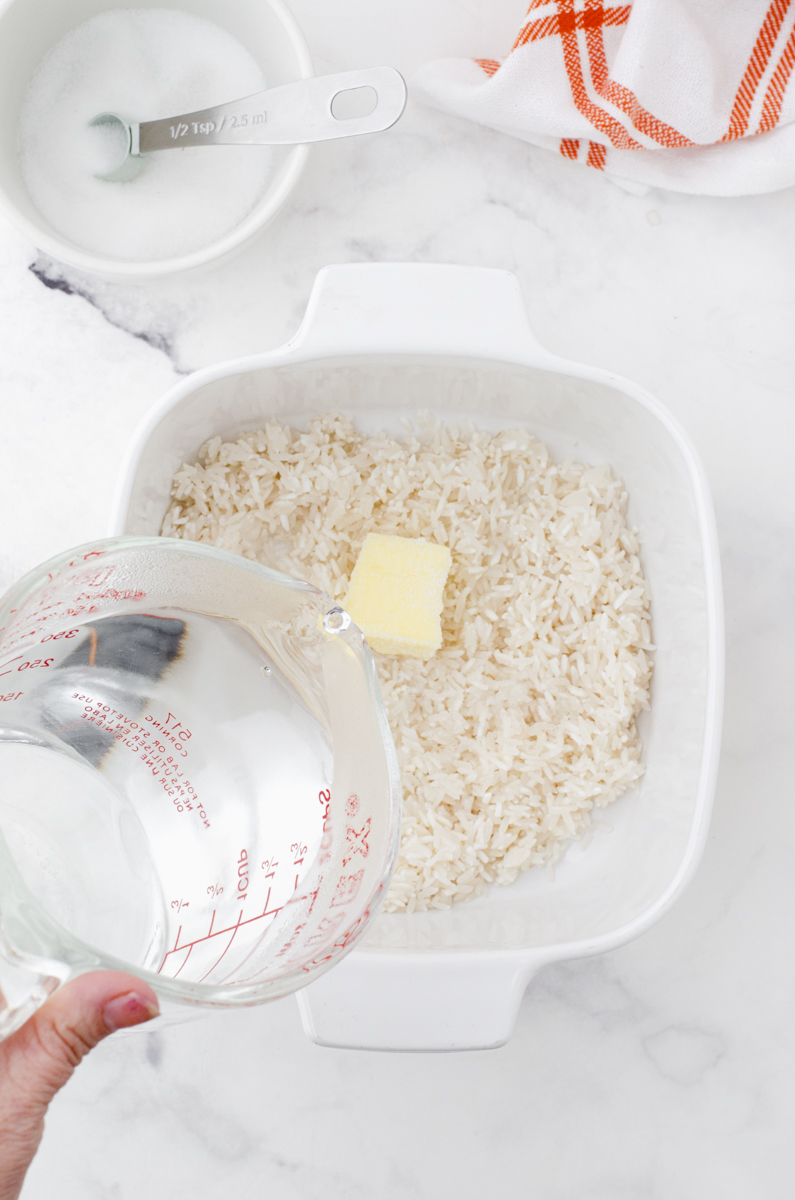 pouring boiling water on to a casserole dish of long grain white rice