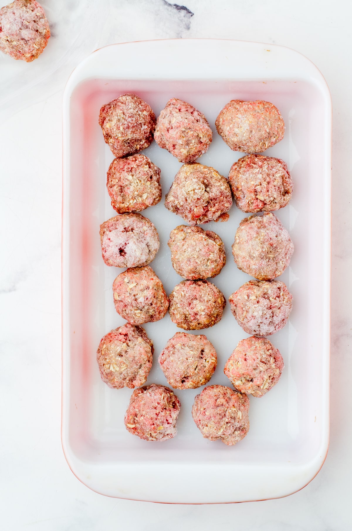 Frozen meatballs in baking dish.