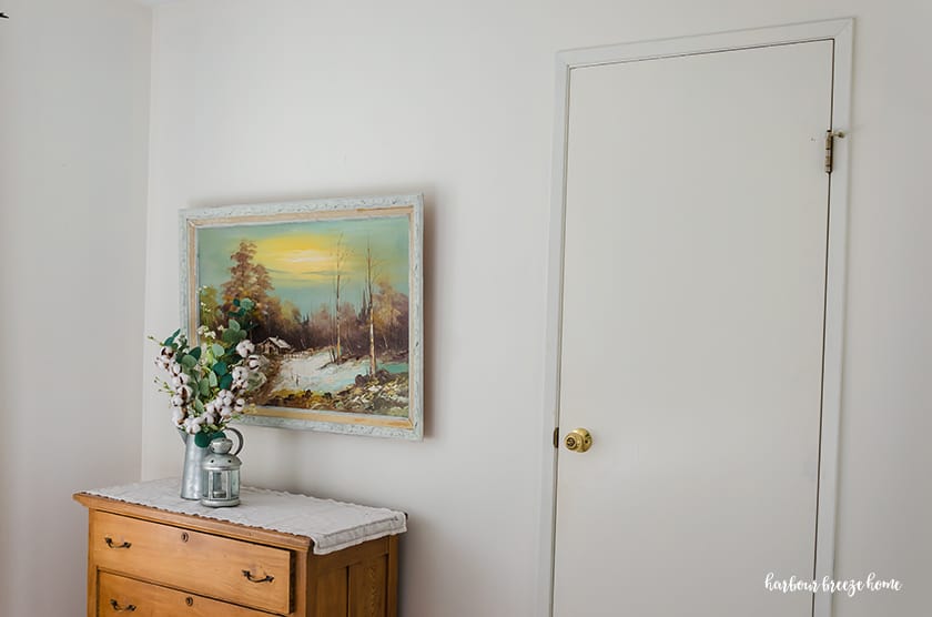 White interior door with thin trim around it and a brass door knob - before new bedroom door knobs