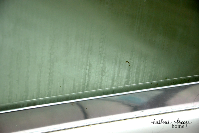 a glass shower door with scummy streaks on it