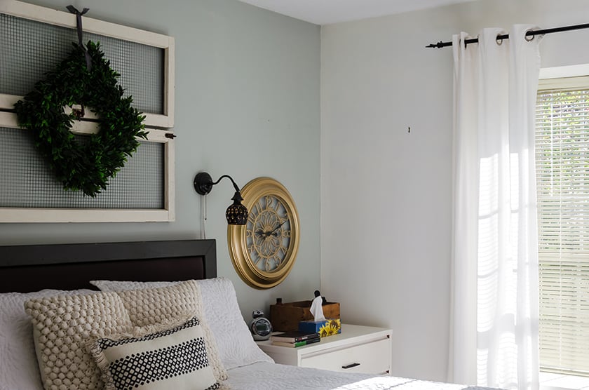 A basic looking bedroom with light blue feature wall and white walls.