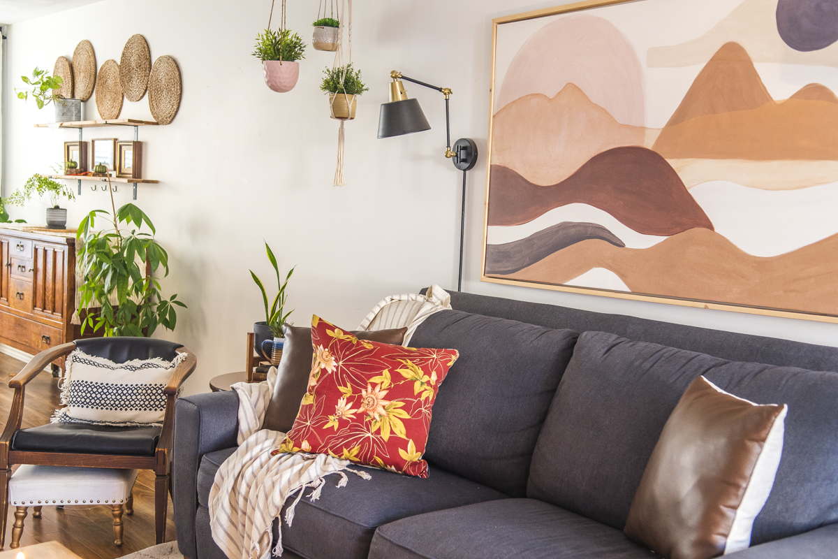 a living room with a boho art print above the couch