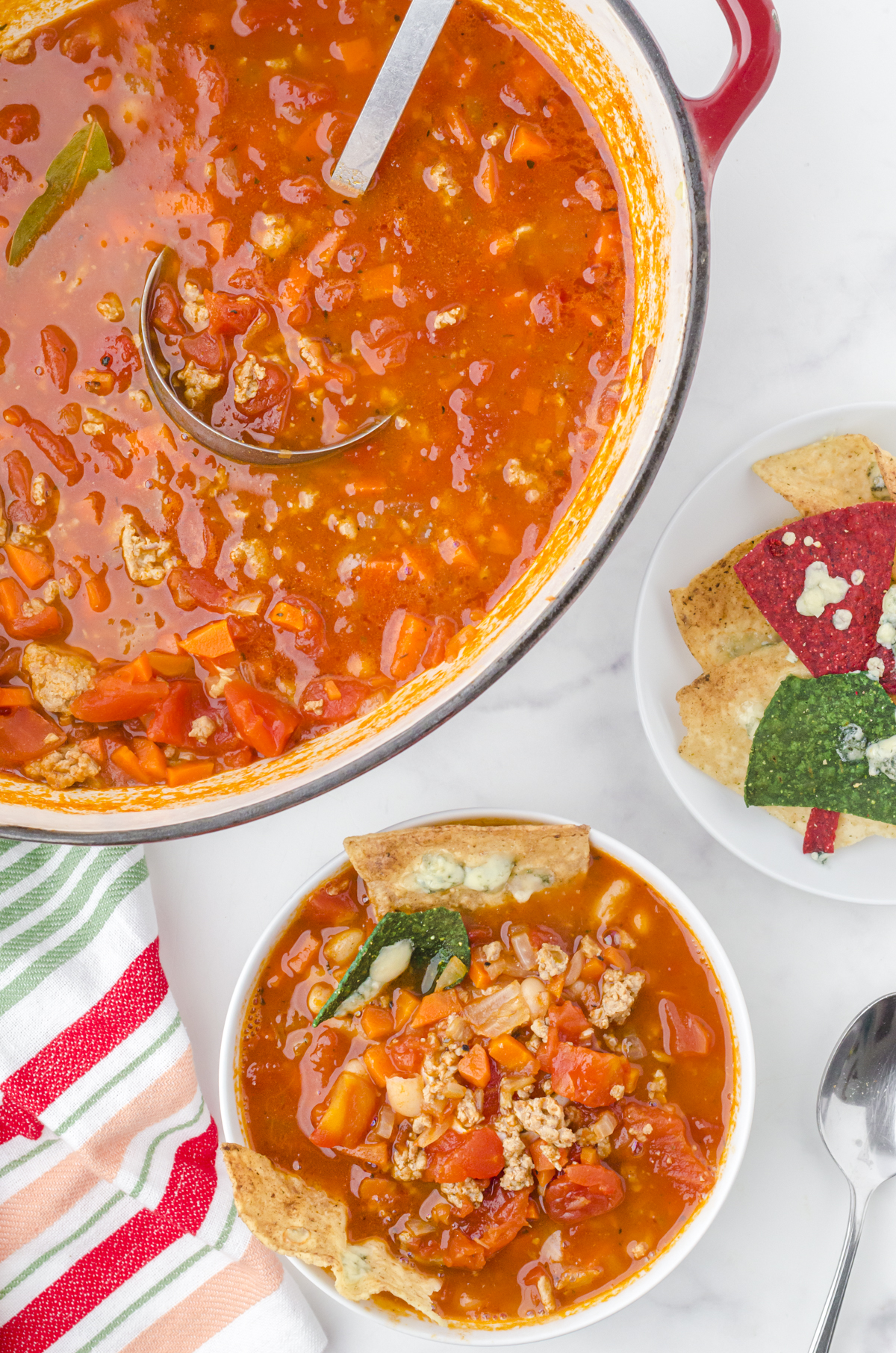 A large pot of Rachel Ray buffalo chicken chili with a bowl beside it.