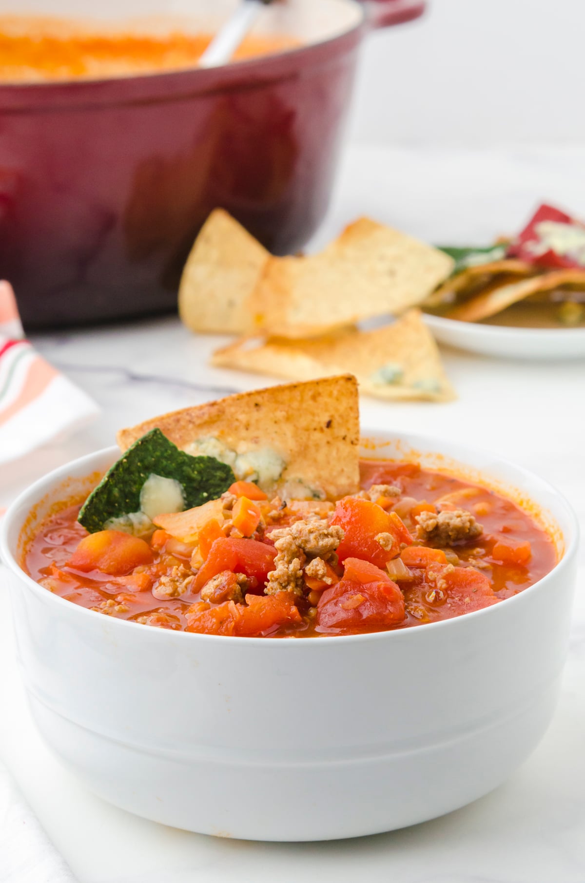Buffalo chicken chili with chips as a garnish in a bowl.