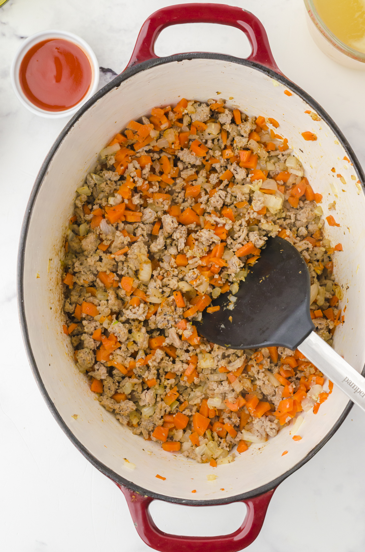 Ingredients being sauted in a dutch oven as the first step for Rachael Ray buffalo chicken chili.