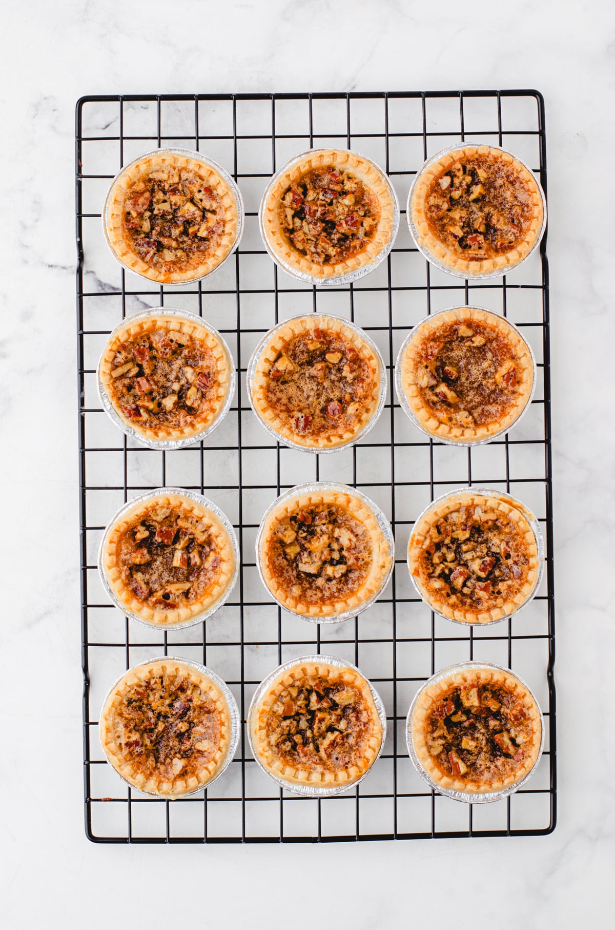 Baked butter tarts cooling on a wire cooling rack.