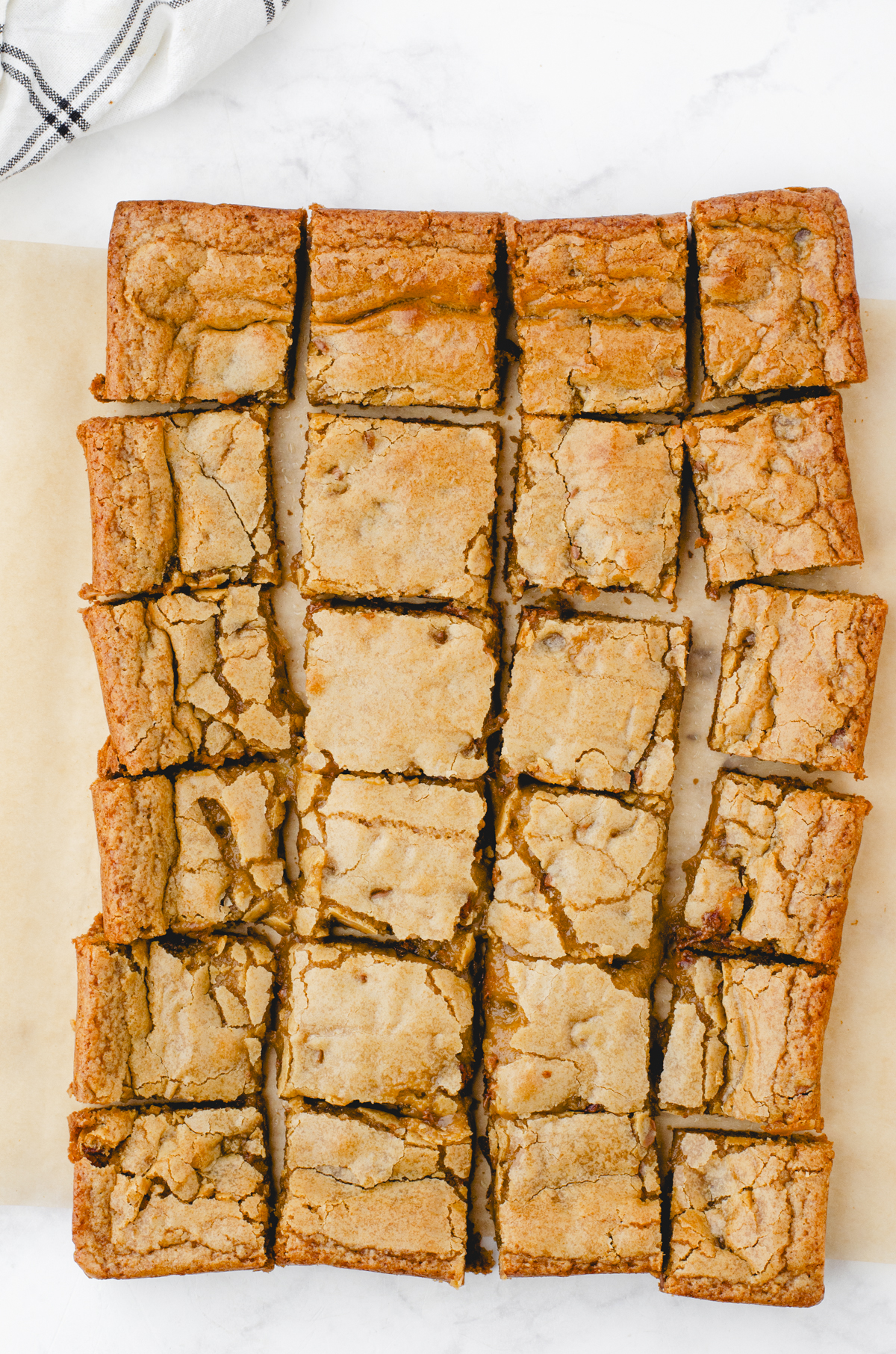 butterscotch brownies cut into squares on top of a piece of parchment paper