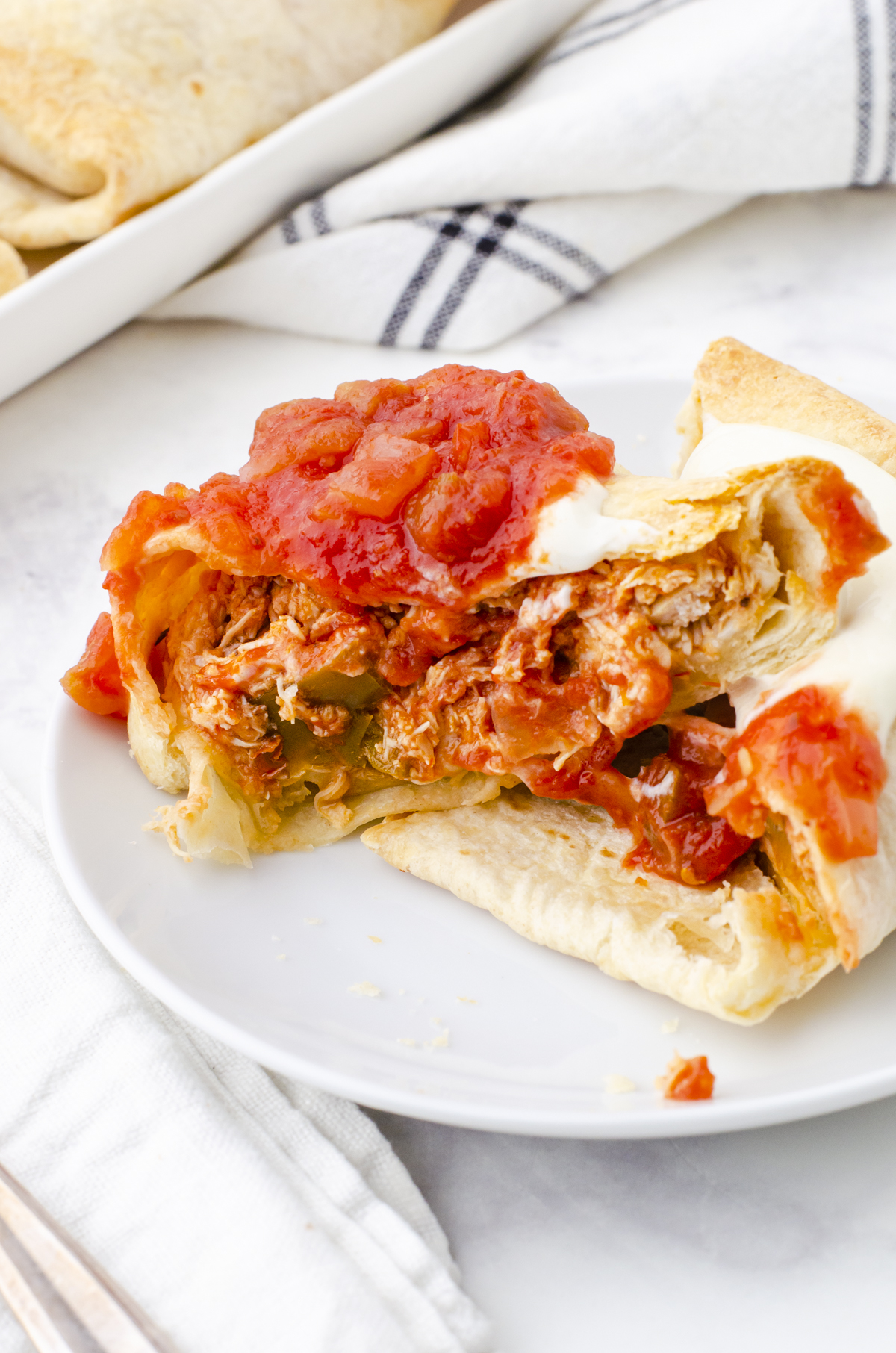 A chicken chimichanga cut in half to show the shredded chicken and cheese filling.