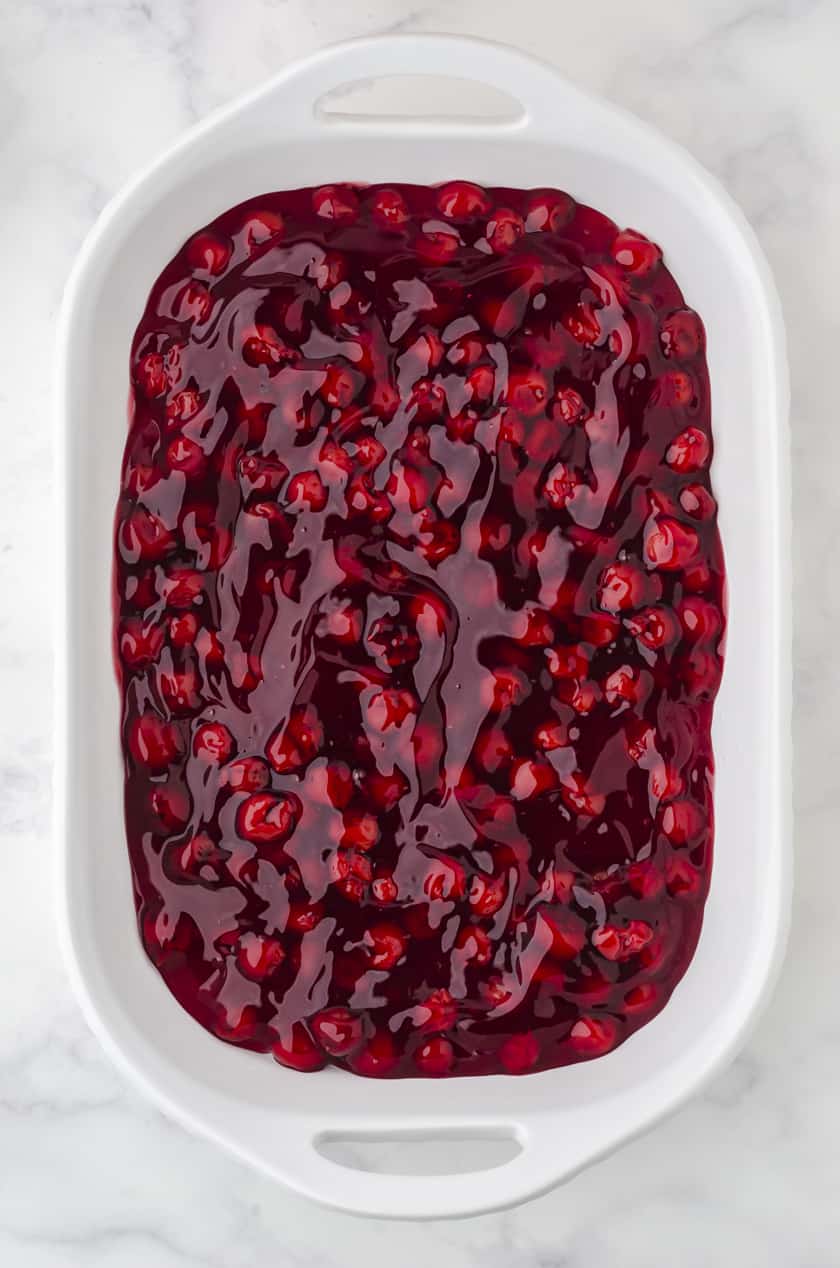 cherry pie filling in a 9x13 inch pan for cherry dump cake recipe