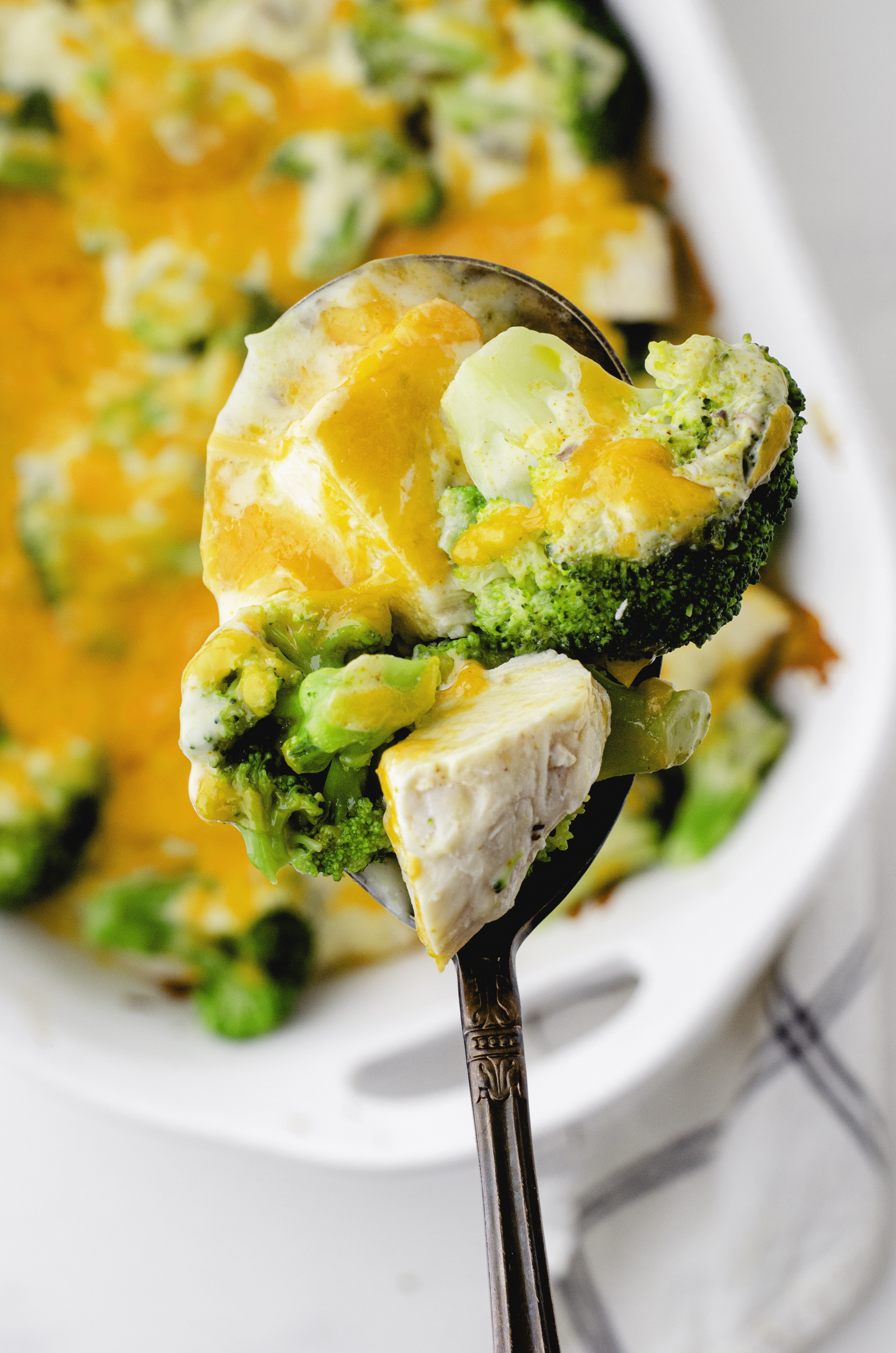 A large serving spoon full of Chicken Divan casserole ingredients - also known as Chicken Broccoli Casserole.