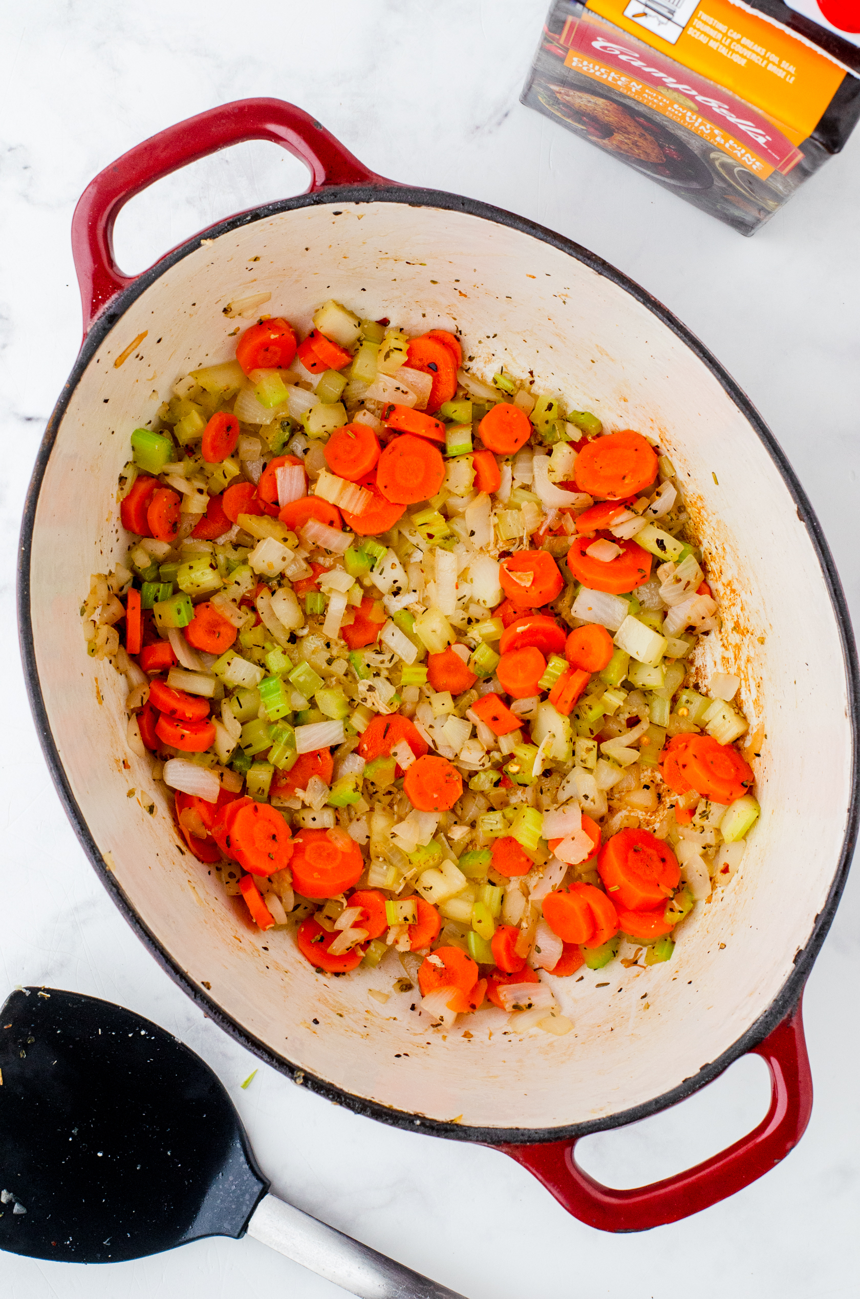 a dutch oven with sauted vegetables in it for chicken noodle soup