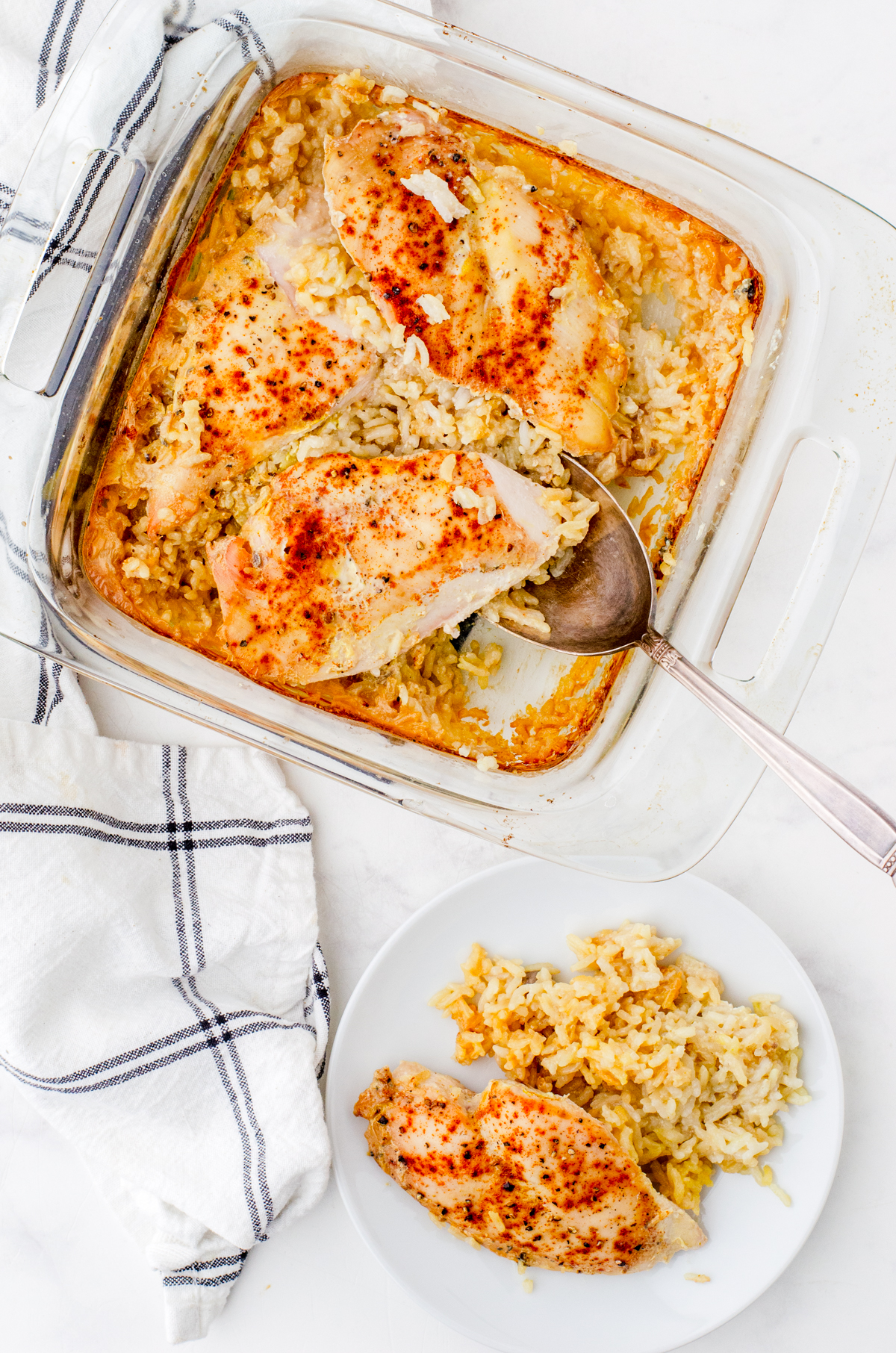 Chicken rice pilar casserole in a baking dish with one serving removed and on a plate.