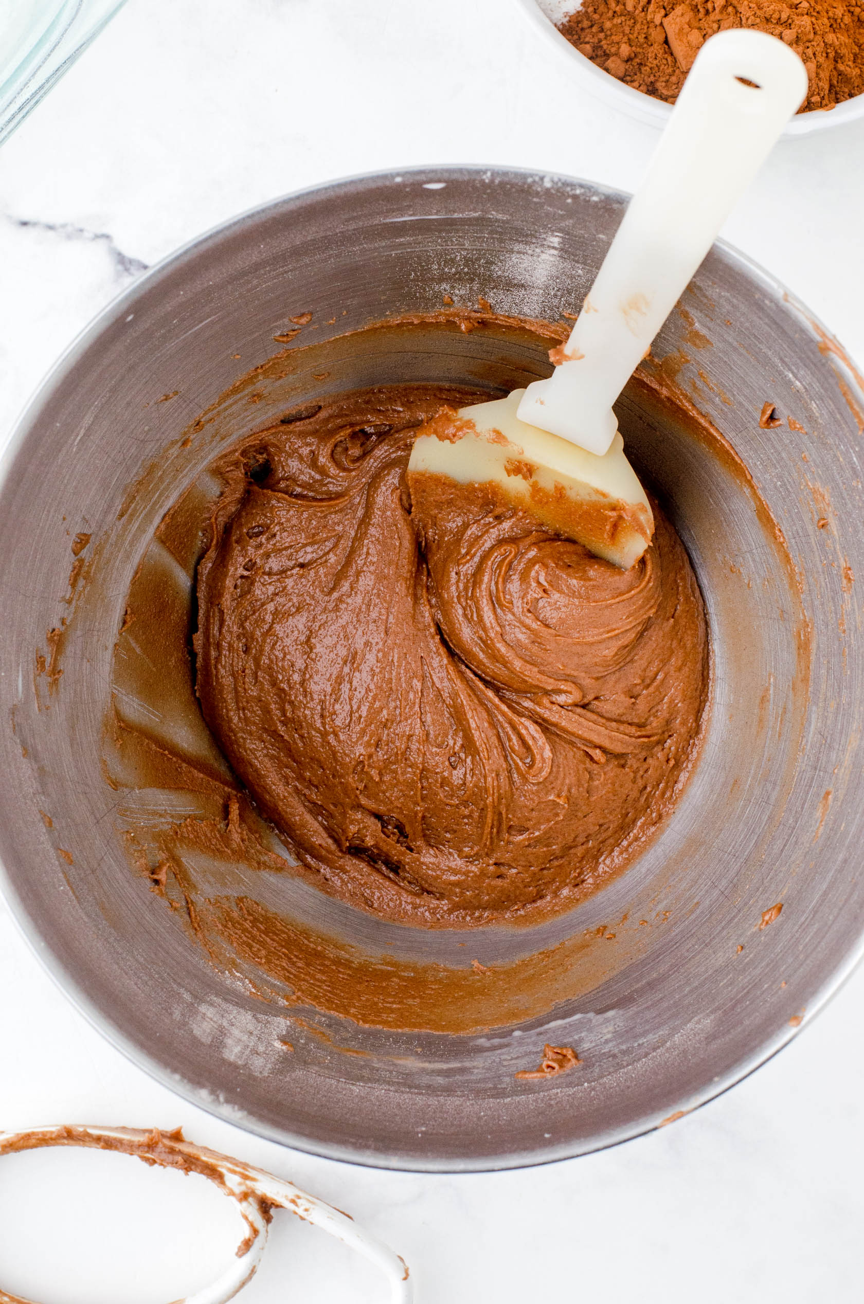 Chocolate pudding cake batter in the bowl of a stand mixer.