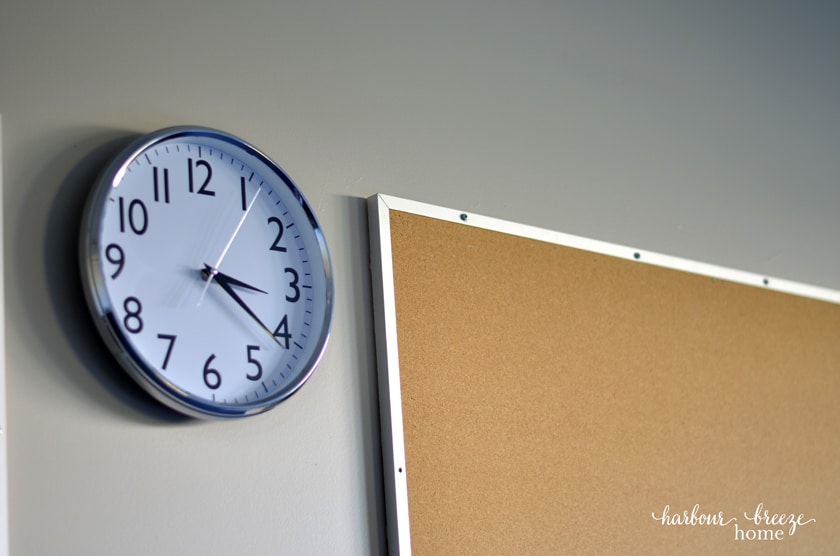 clock beside a bulletin board