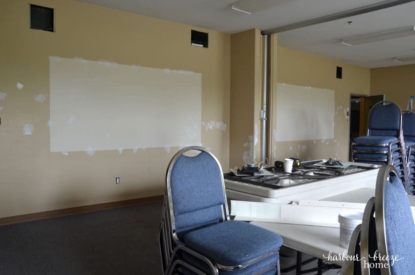 Walls of a large classroom with repaired holes