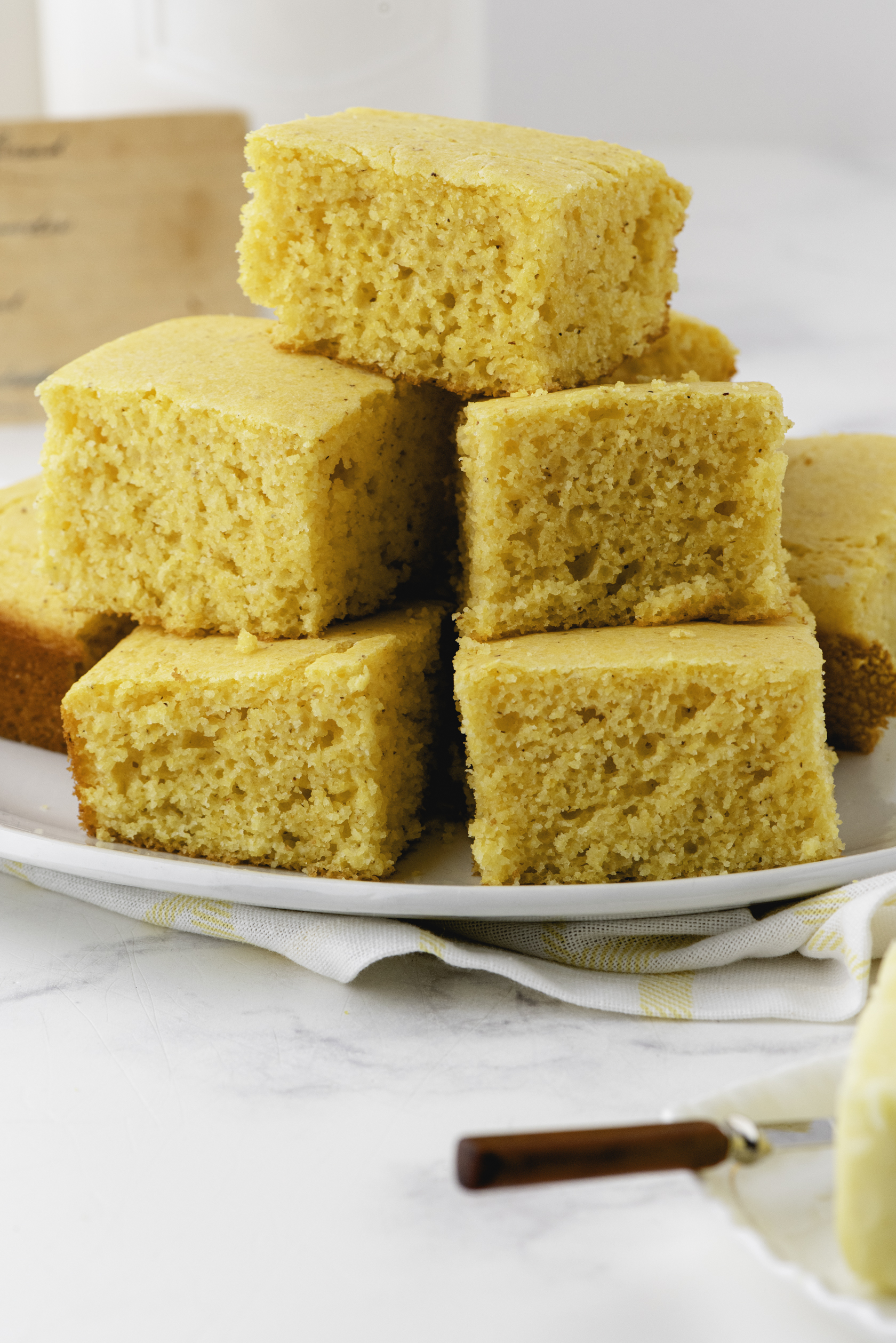 Pile of cornbread pieces in squares on a large serving platter.