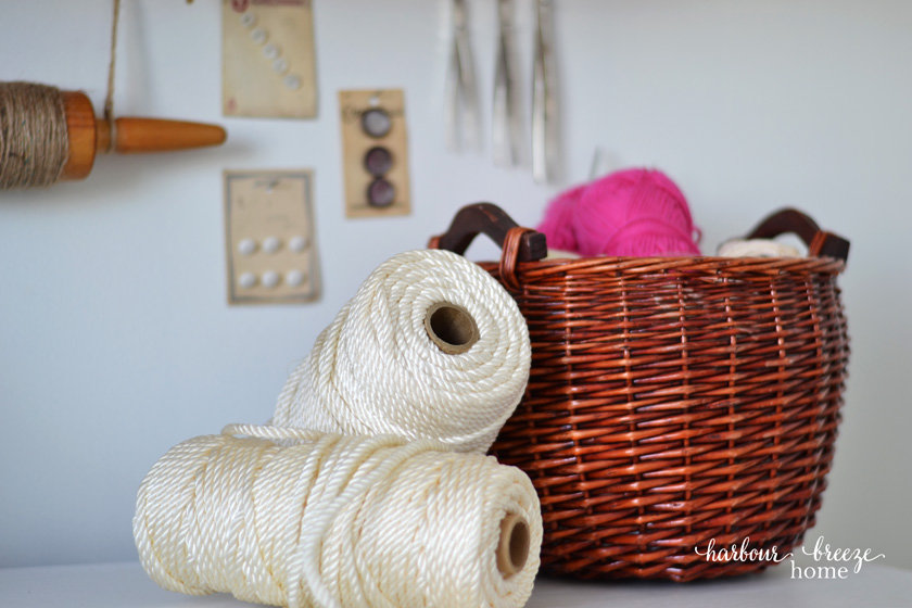 A Basket of Yarn and rolls of macrame sitting on a dresser top