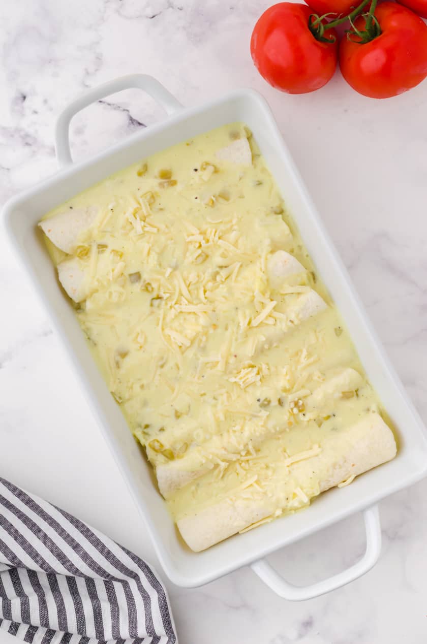 A pan of creamy chicken enchiladas assembled and ready to put in the oven.