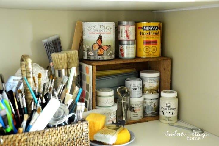 craft paints and brushes organized on a closet shelf