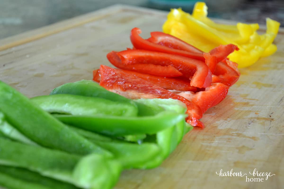 Peppers lined up and sliced on a cutting board
