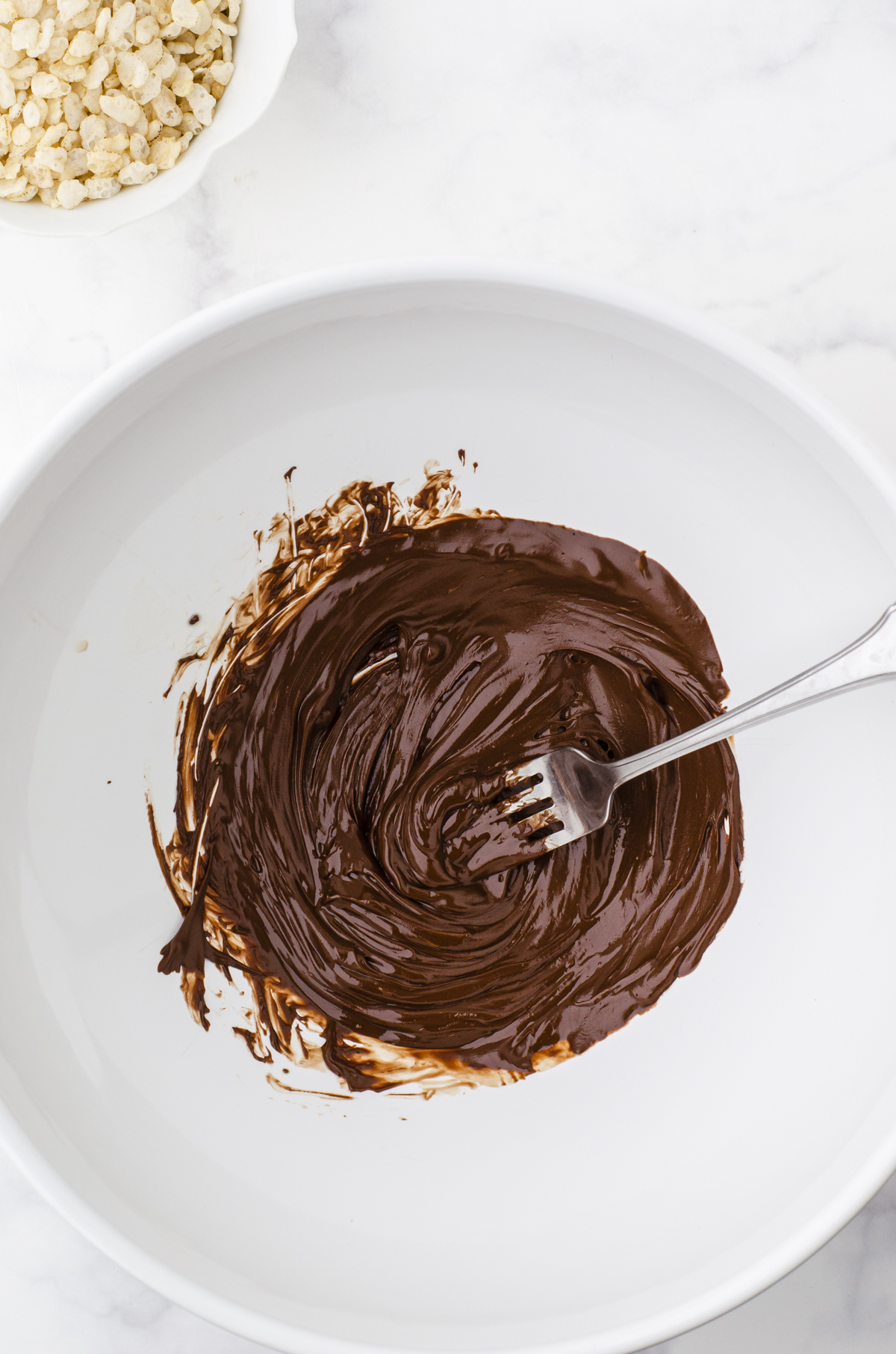 Melted chocolate in a mixing bowl to be used for crispy rice chocolate bar recipe.