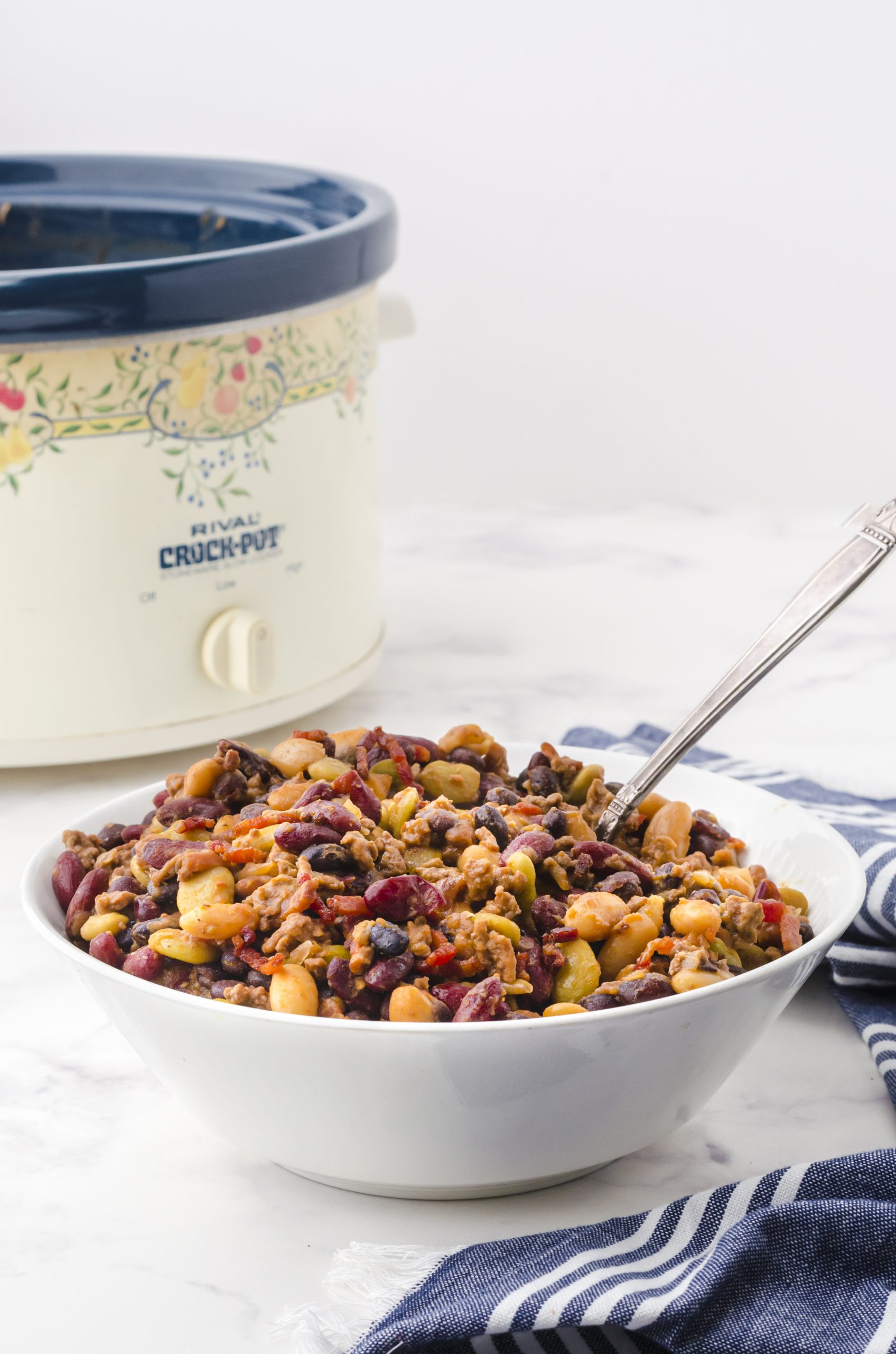 A serving bowl full of crock pot baked beans.