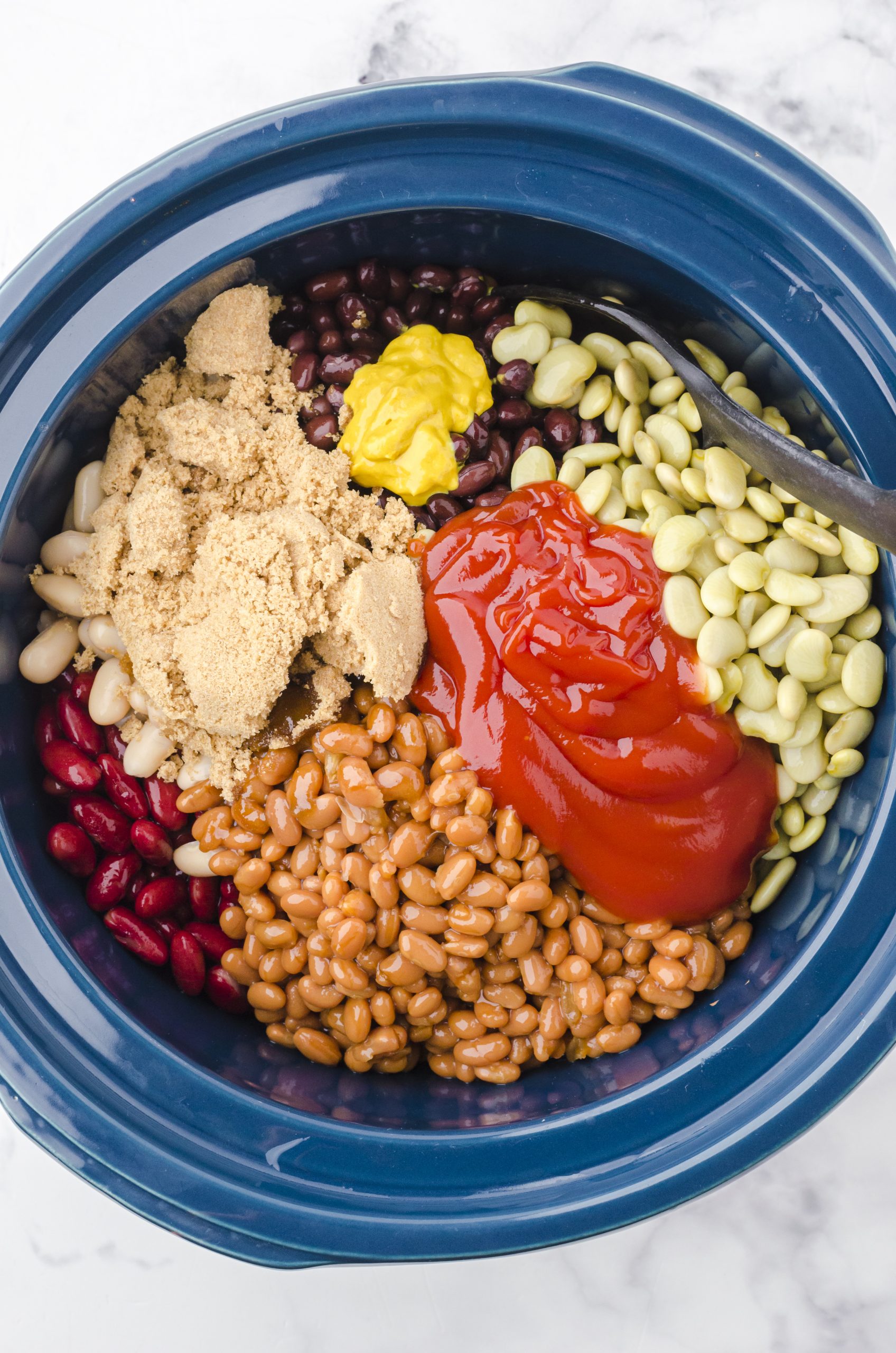 Crock pot baked beans ingredients in a crock pot.
