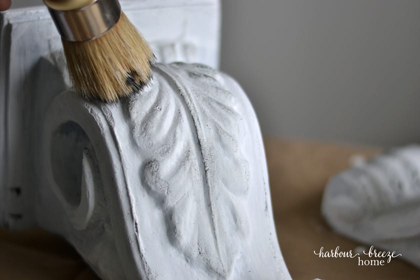 Drybrushing gray paint onto a white painted corbel