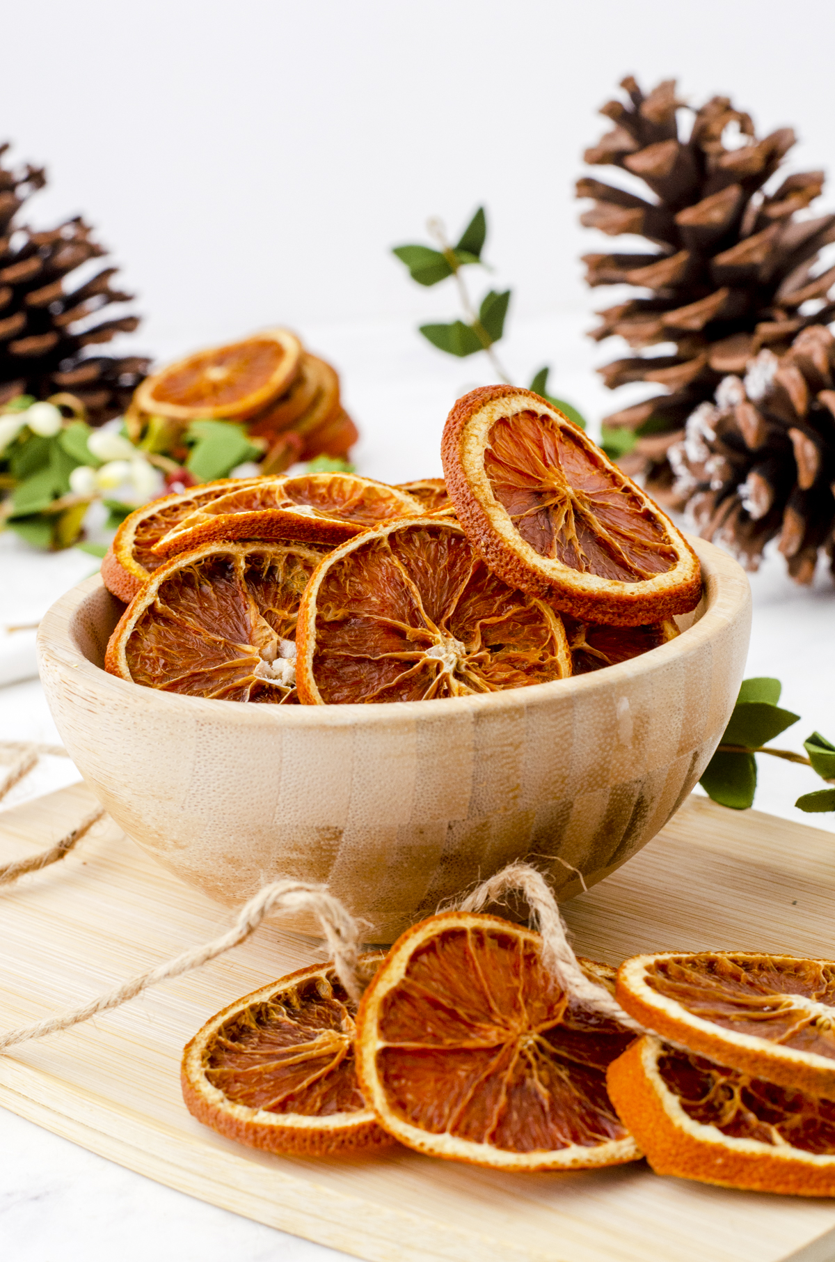 Dried orange slices sitting in wooden bowl.