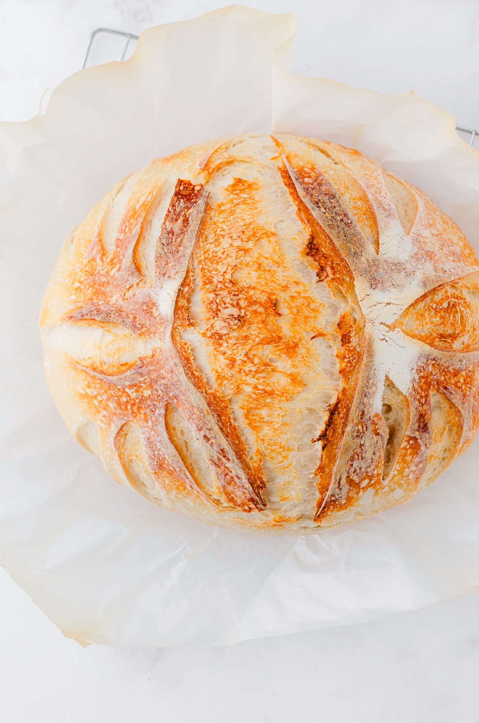 A baked sourdough loaf after it has been removed from the dutch oven.