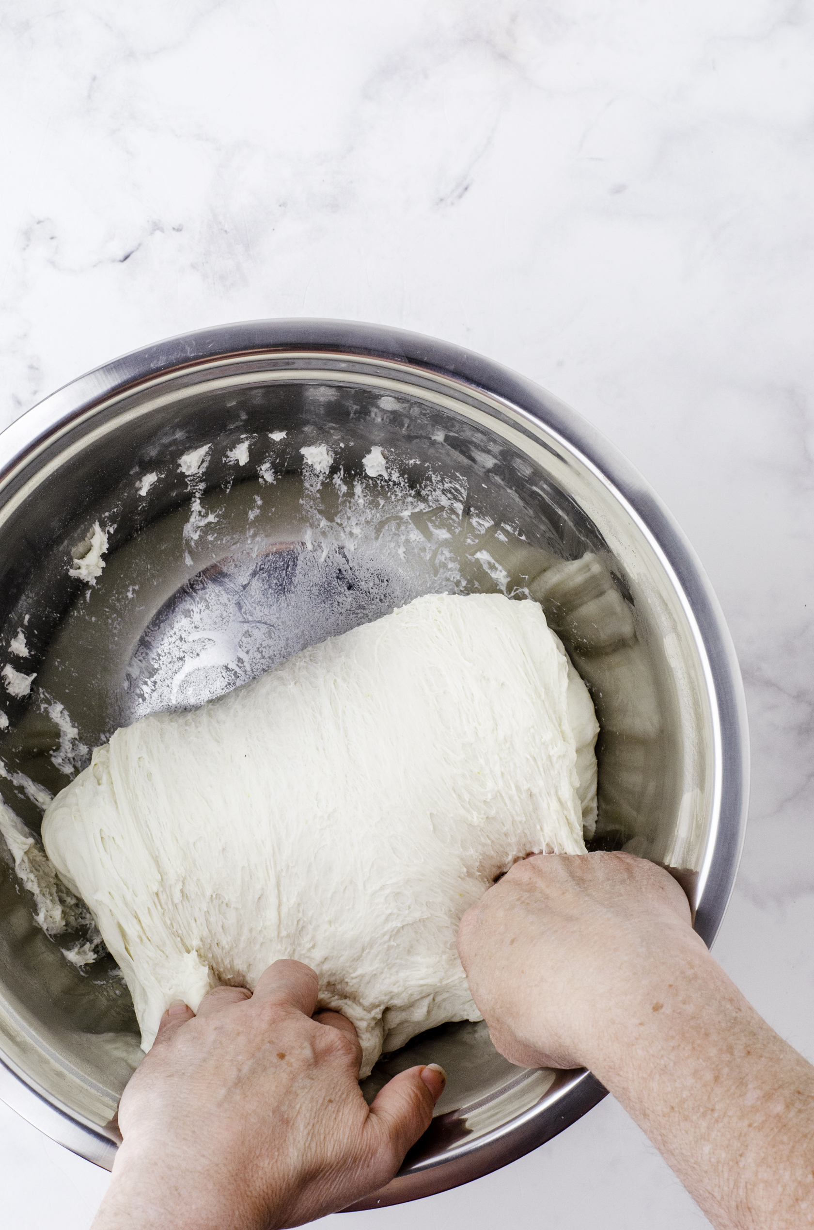 Folding the sourdough over itself in a large bowl.