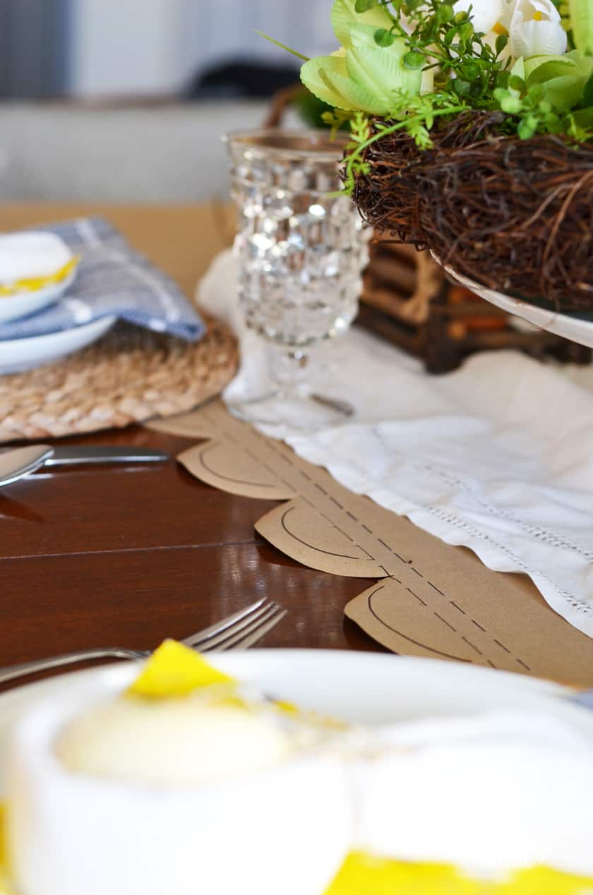 Easter tablescape with a brown paper table runner with scalloped edges.
