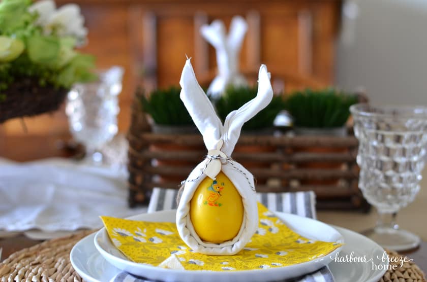 Bunny ear napkins sitting on top of a white plate.