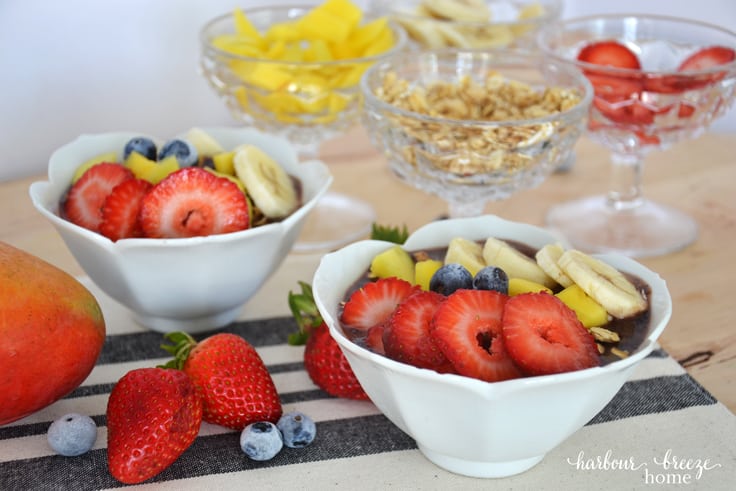 2 bowls of acai berry smoothie topped with fresh fruit