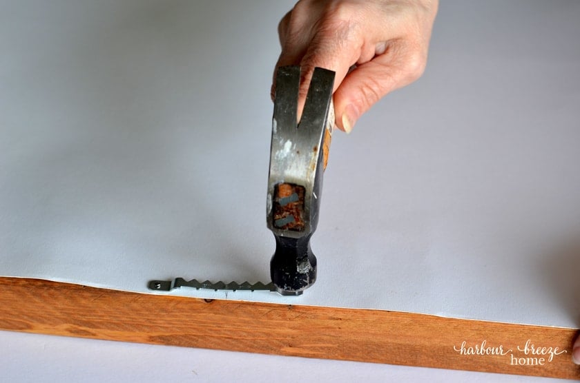 Hammer a sawtooth hanger to the back of the picture frame to hang it on a wall.