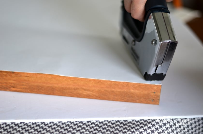 Use a staple gun to attach the art or poster to the finished diy picture frame.